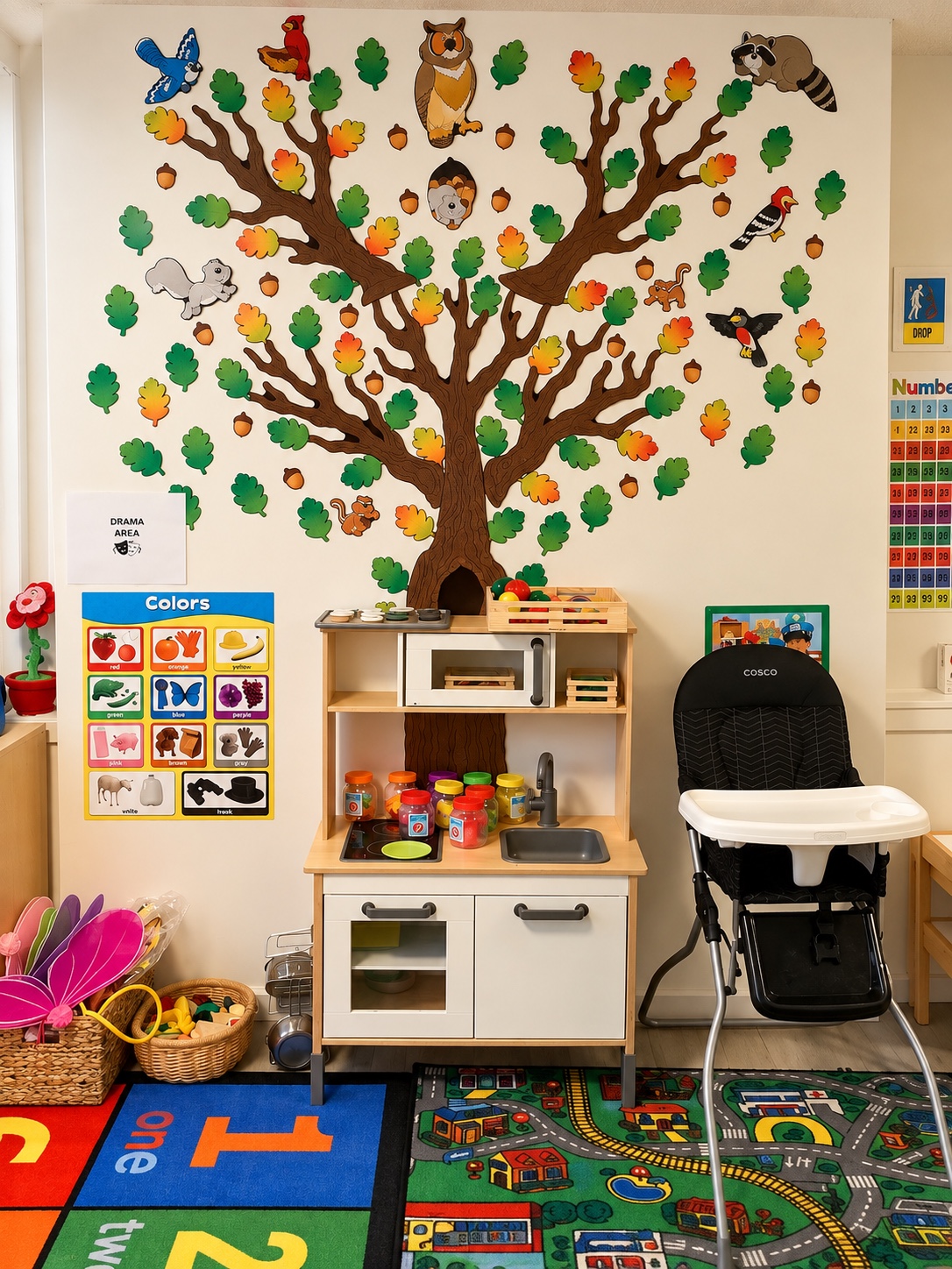 Pretend kitchen beneath a colorful tree and animal wall display